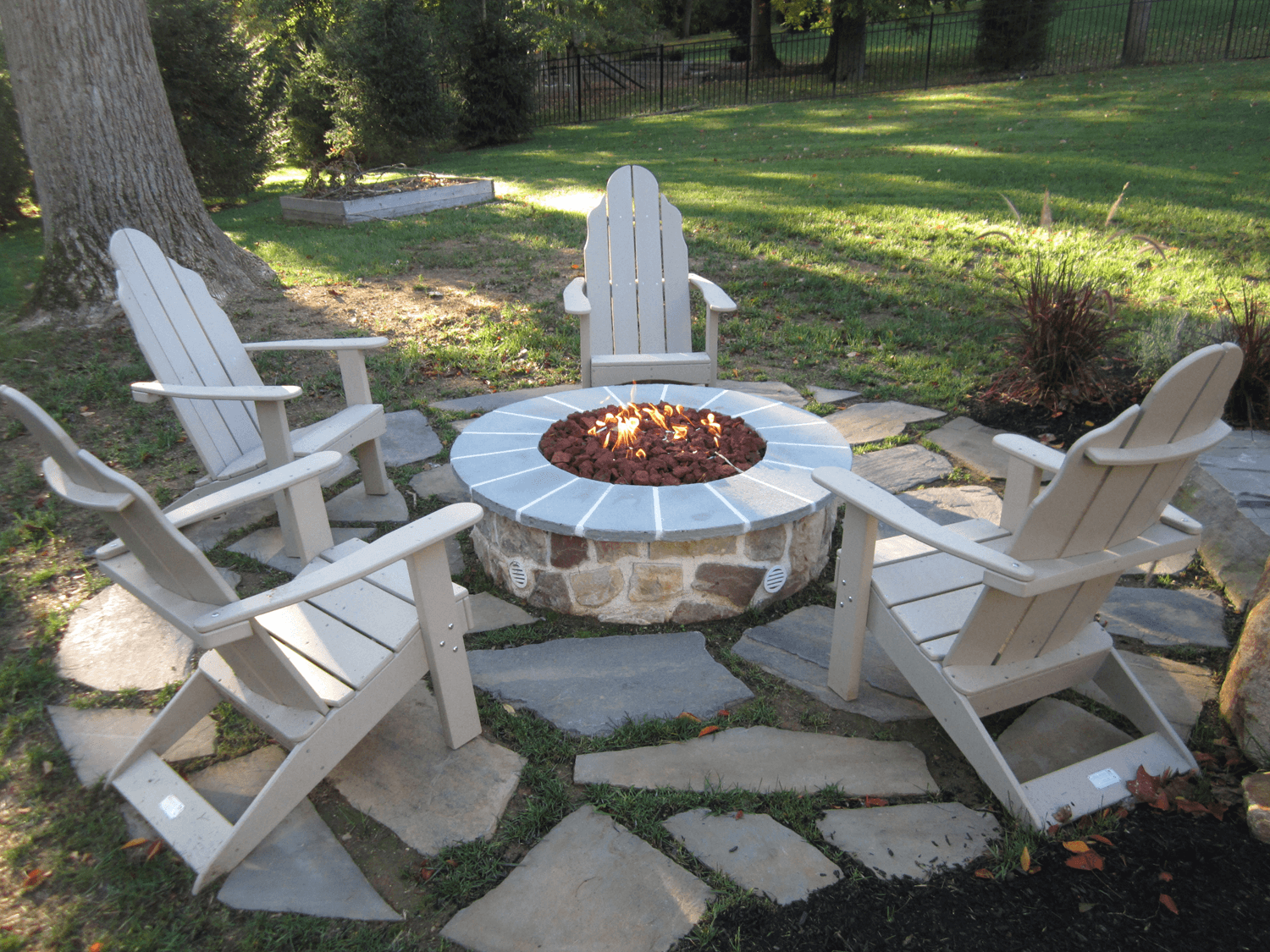 chairs around a firepit on a patio- investing in landscape design- Burkholder Landscape