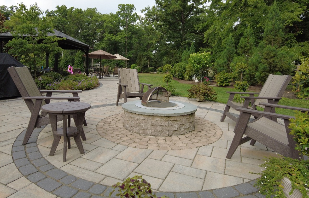 chairs around a firepit on a round patio- investing in landscape design- Burkholder Landscape