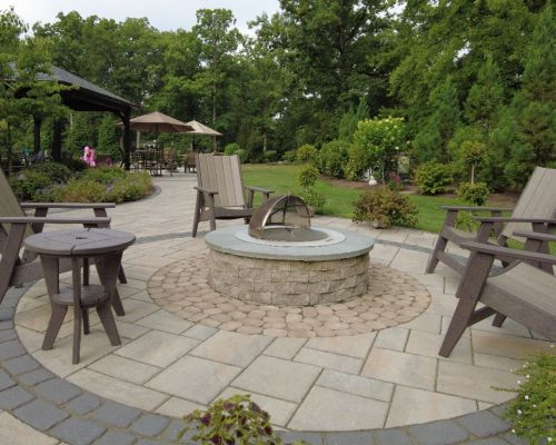 chairs around a firepit on a round patio- investing in landscape design- Burkholder Landscape