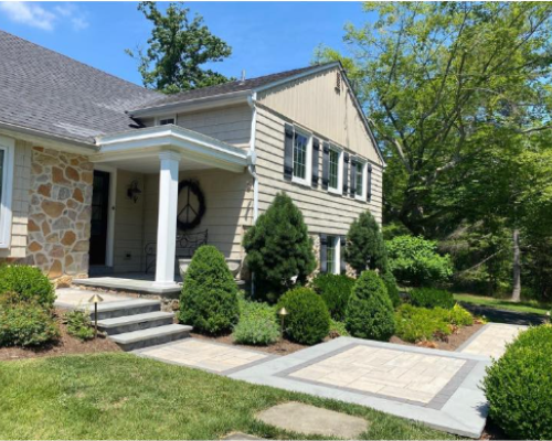 Backyard Oasis from rear, outdoor furniture with black accessories, spa, outdoor kitchen and large Blu Grande pavers by Techo-Bloc - by Burkholder Landscape